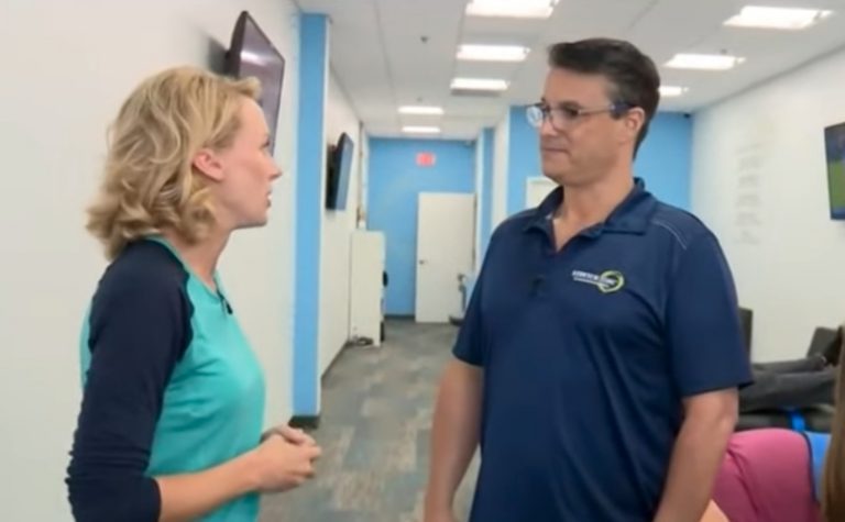 Experienced fitness trainer guiding a client through a personalized stretching routine at Stretch Zone studio